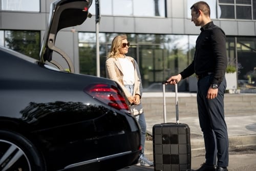 Chauffeur helps a customer with her bags at the Black Car Service.